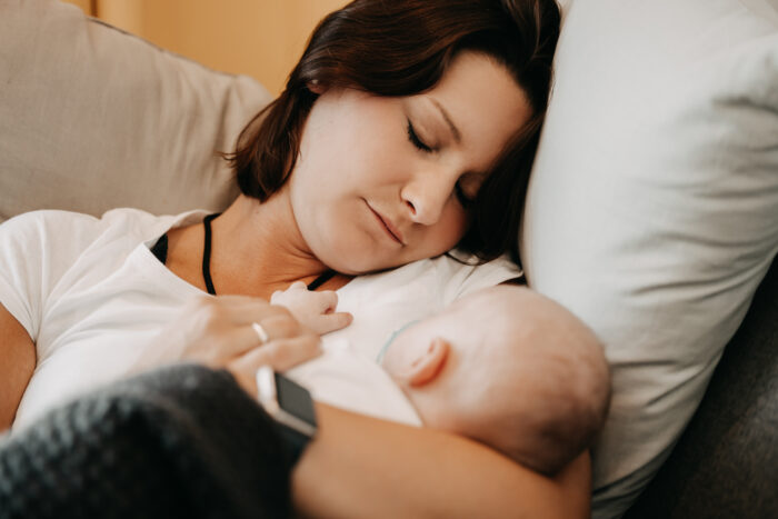Schlafende Mutter hält schlafendes Kind im Arm
